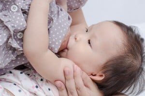 Asian mom breast feeding her baby girl